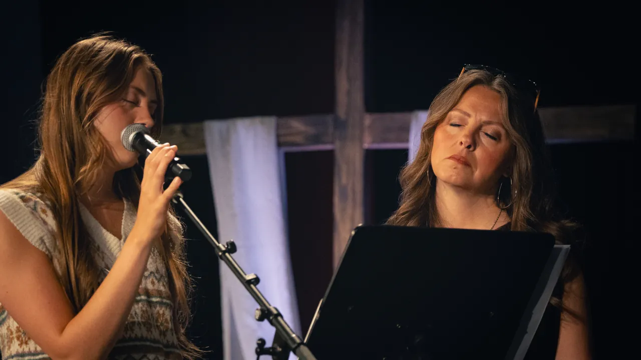 Two women worshiping with eyes closed at Breakthrough Church